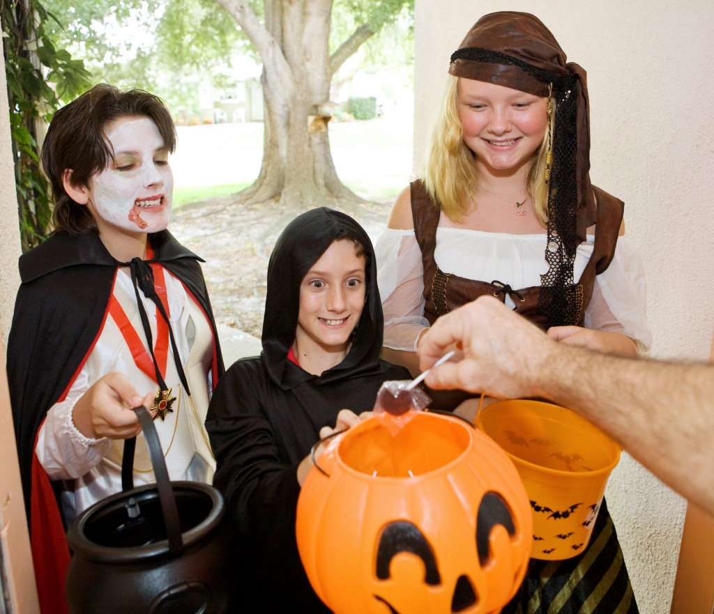 Adorable trick or treaters in the doorway waiting for candy.