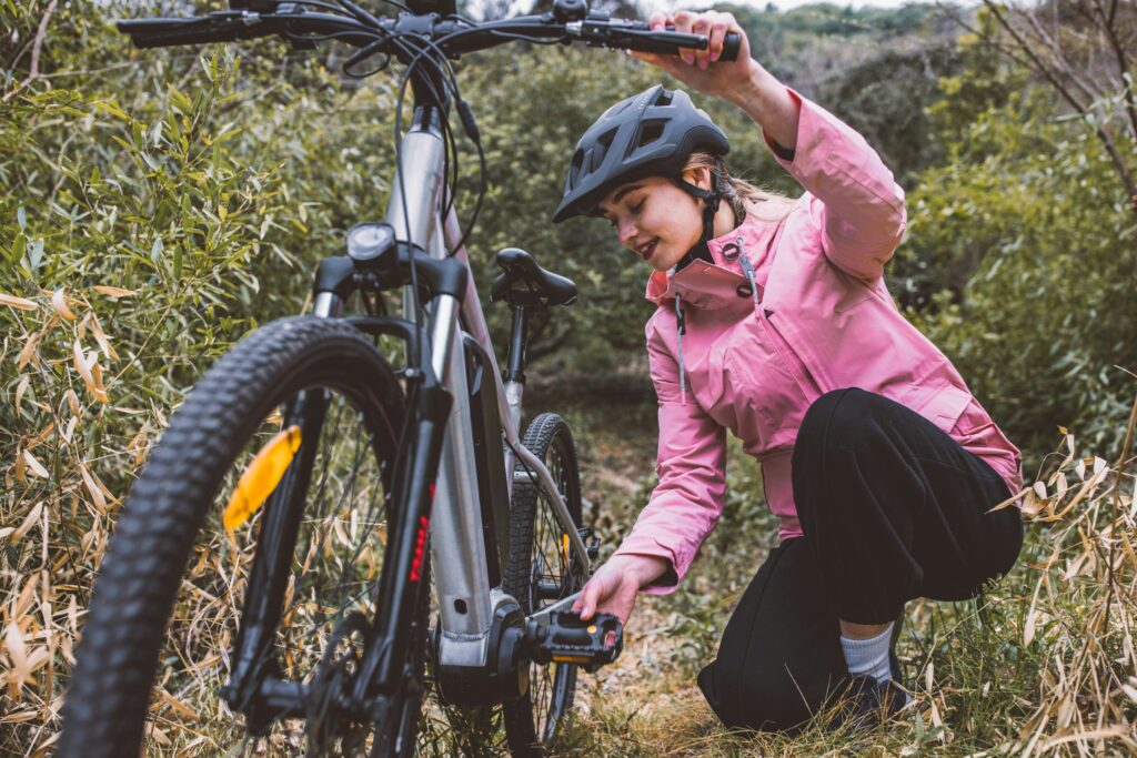 Woman making inspecting her bike to avoid bike injuries in Portland